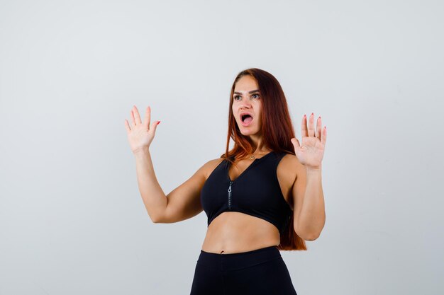 Young sporty woman with long hair being shocked