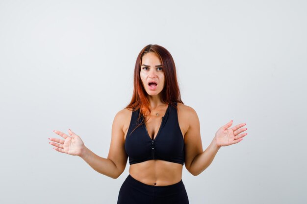 Young sporty woman with long hair being shocked