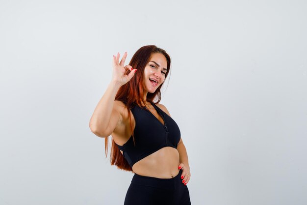 Young sporty woman with long hair in a black top