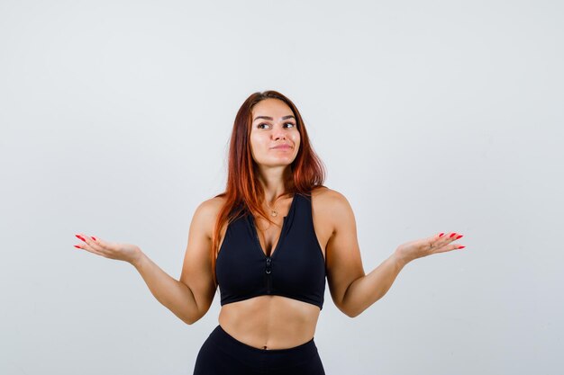 Young sporty woman with long hair in a black top