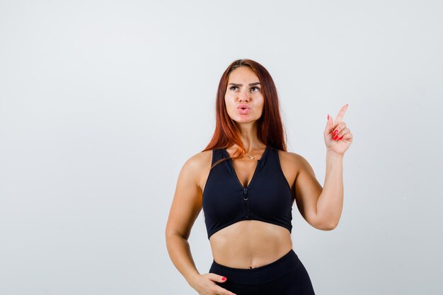 Young sporty woman with long hair in a black top