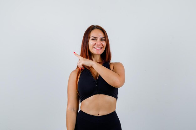 Young sporty woman with long hair in a black top