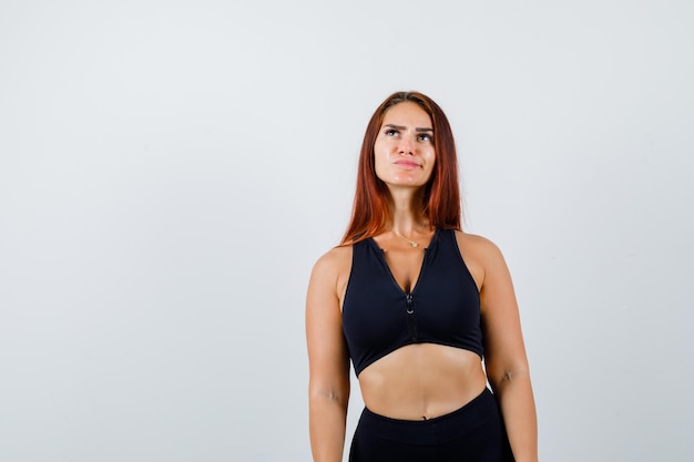 Young sporty woman with long hair in a black top