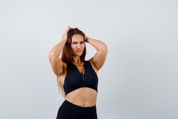 Young sporty woman with long hair in a black top