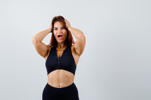 Giovane donna sportiva con i capelli lunghi in un top nero