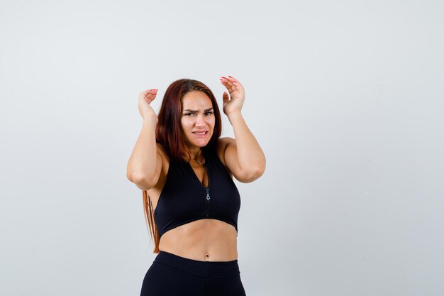 Young sporty woman with long hair in a black top