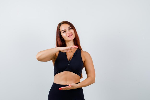 Young sporty woman with long hair in a black top