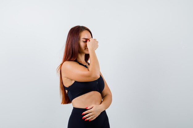 Young sporty woman with long hair in a black top