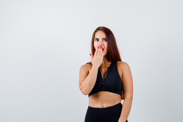 Young sporty woman with long hair in a black top