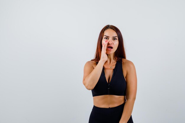 Young sporty woman with long hair in a black top