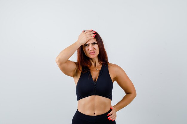 Young sporty woman with long hair in a black top