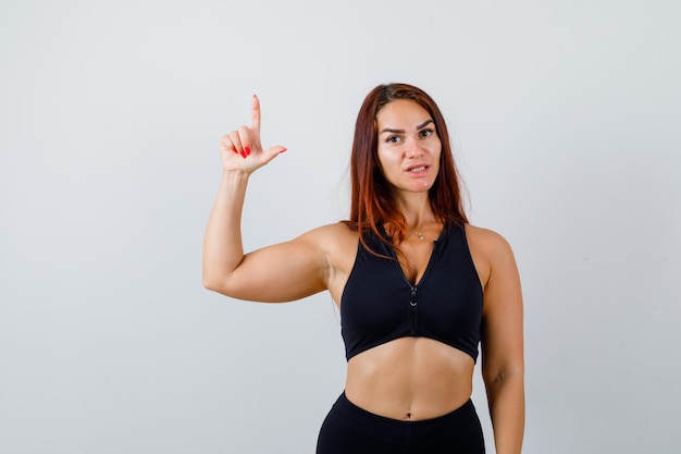 Young sporty woman with long hair in a black top