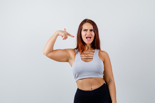 Young sporty woman with long hair in a gray top