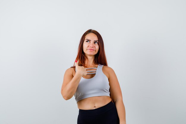 Giovane donna sportiva con i capelli lunghi in un top grigio