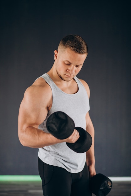 Giovane uomo forte che si esercita in palestra