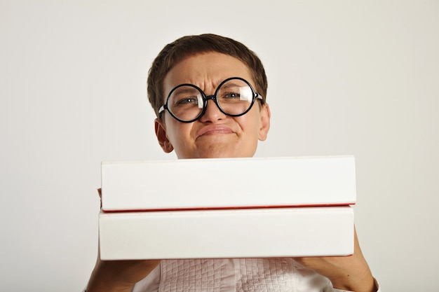 Young student girl shows emotional expression and dissapointment because of starting new paper work in document folders she holds in front of her