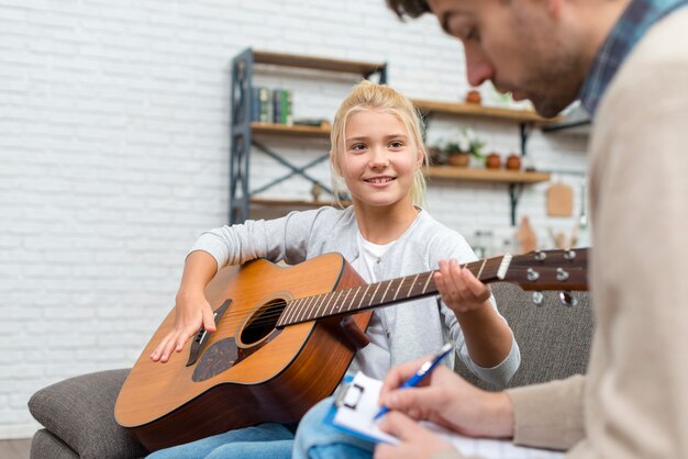 Young student learning how to play guitar