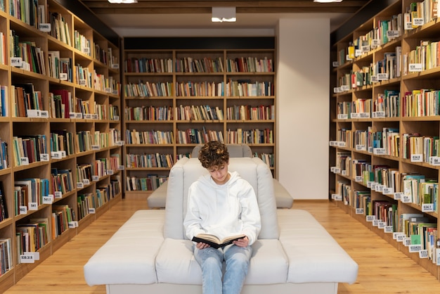 Foto gratuita giovane studente che impara in biblioteca