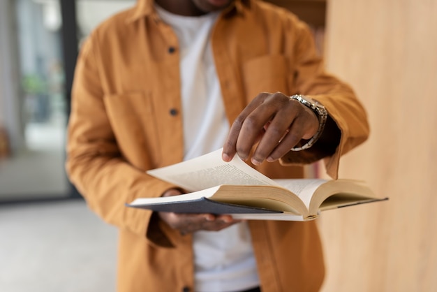 Foto gratuita giovane studente che impara in biblioteca