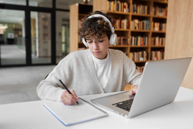 Giovane studente che impara in biblioteca