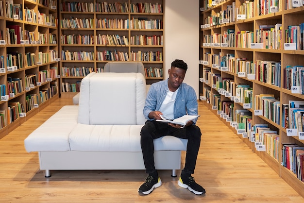 Giovane studente che impara in biblioteca