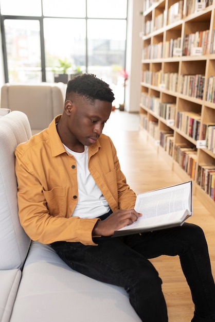 Foto gratuita giovane studente che impara in biblioteca