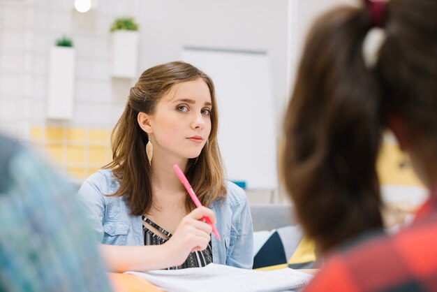 Young student posing at table in library