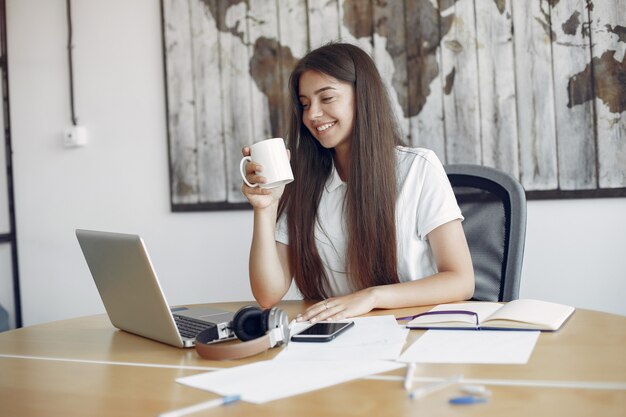 Young student sitting at the table and use the laptop