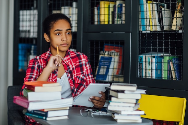 Free photo young student sitting at university library during break from studying