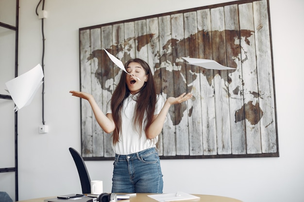 Young student standing in the office and throws up the documents