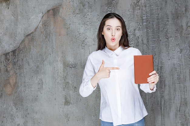 Free photo young student or teacher pointing at literature book. high quality photo