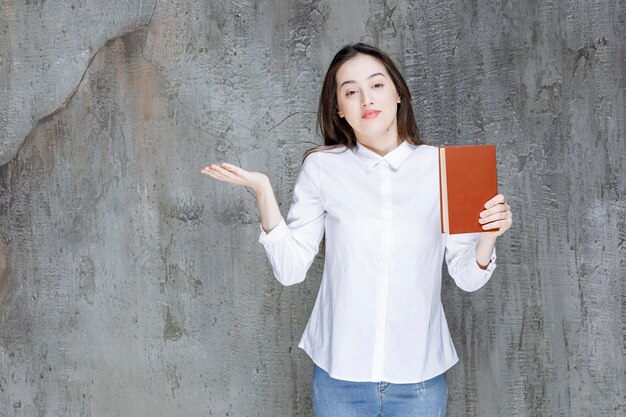 문학 책을 보여주고 열린 공간을 들고 있는 젊은 학생이나 교사. 고품질 사진