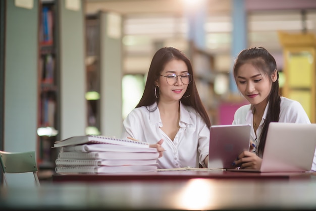 Young students learning, library bookshelves 