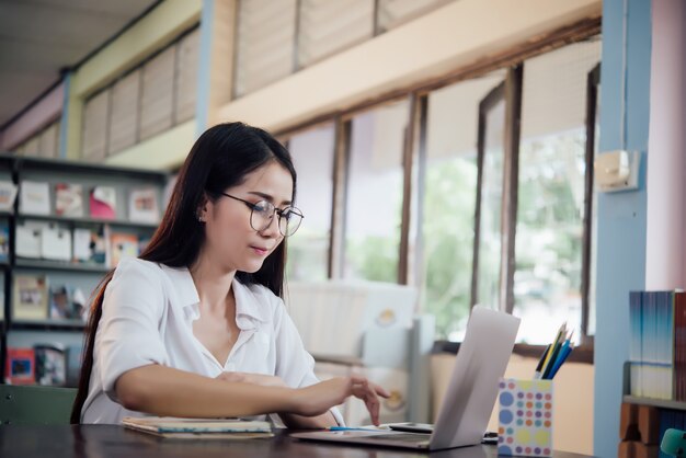 学んでいる若い学生、図書館の本棚