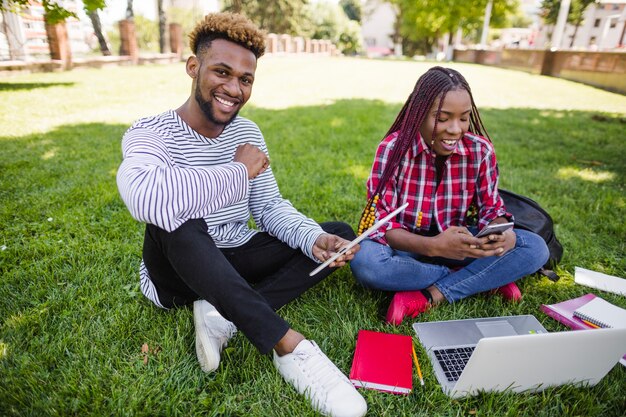 Young students studying on meadow