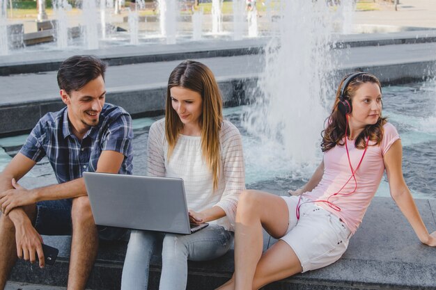 Young students with laptop in park