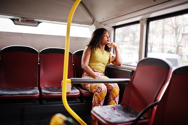 Foto gratuita giovane donna afroamericana alla moda che guida su un autobus