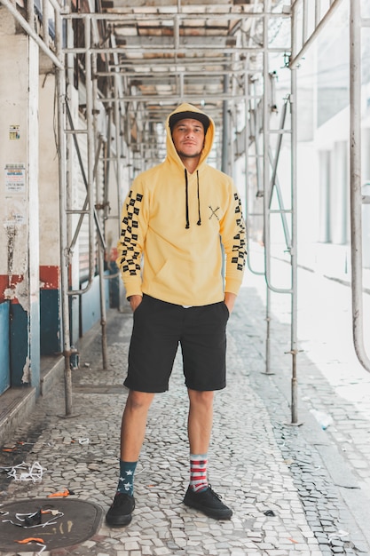 Young stylish boy in the streets under scaffolding