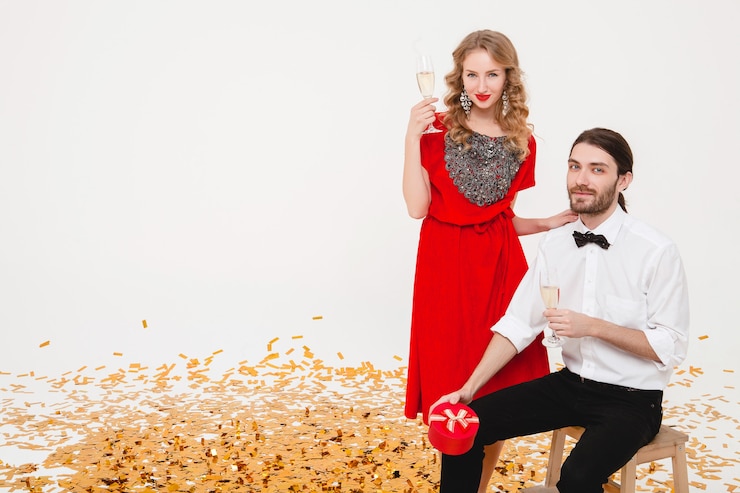 मुफ़्त फोटो young stylish couple in love holding glasses and drinking champagne, celebrating new year