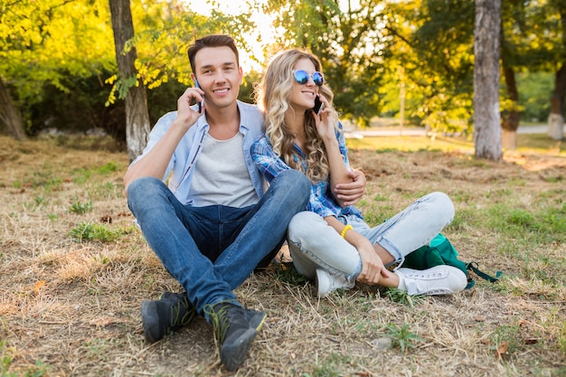 Young stylish couple sitting in park, man and woman happy family together