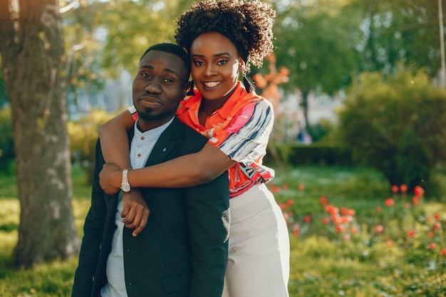 A young and stylish dark-skinned couple standing in a sunny city