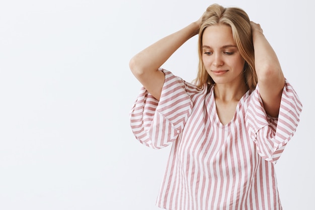 Young stylish girl posing against the white wall