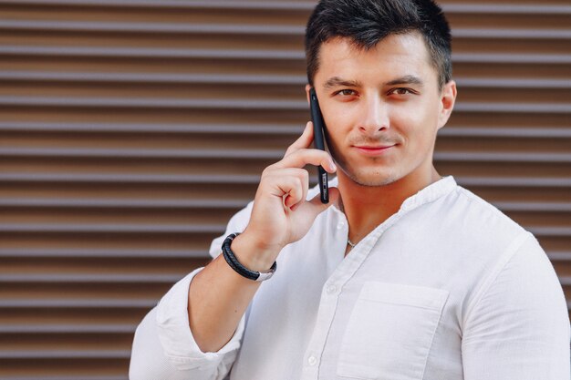 Young stylish guy in shirt talking by phone 