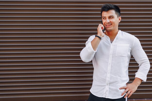 Young stylish guy in shirt talking by phone 