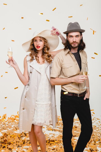 Young stylish hipster couple in love, holding glasses and drinking champagne