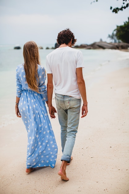 Young stylish hipster couple in love on tropical beach during vacation