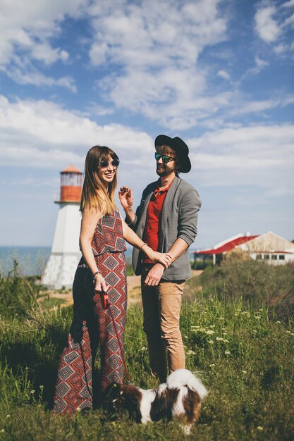 시골에서 강아지와 함께 산책하는 사랑에 젊은 유행 hipster 부부