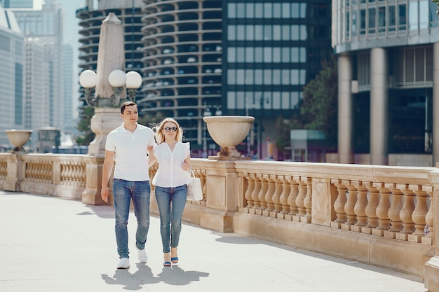 Free photo young and stylish lovers couple in white t-shirts and blue jeans walking in a big city