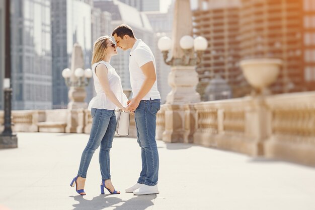 молодые и стильные пары в белых футболках и голубых джинсах, гуляющих в большом городе