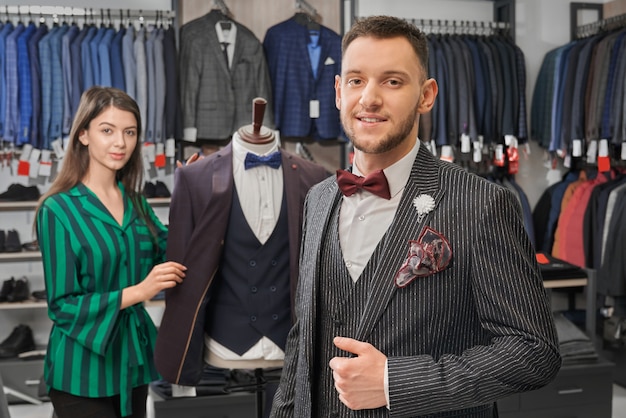 Free photo young, stylish man in elegant suit posing in shop.